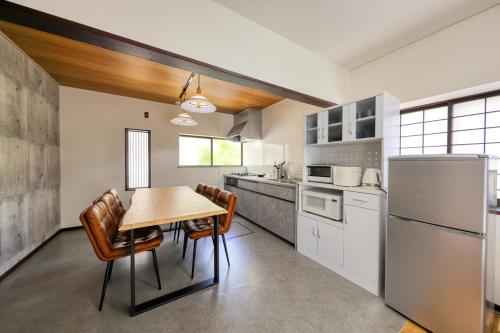a kitchen with a table and chairs and a refrigerator at Yoshimura igariya in Azagawa