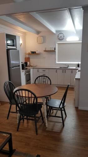 a kitchen with a table and chairs in a kitchen at At Home Apartments in Sale