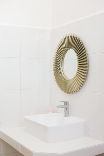 a white bathroom with a mirror and a sink at Tortuga LAS COLORADAS in Yuluc