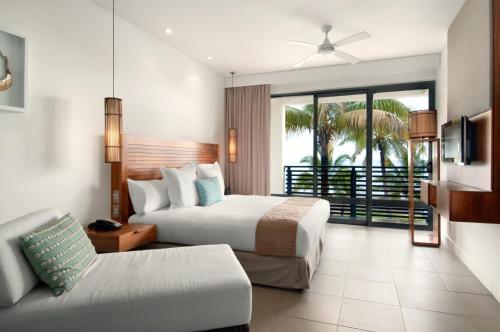 a hotel room with two beds and a couch at Hilton Fiji Beach Resort and Spa in Denarau
