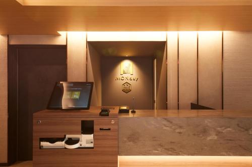 a room with a desk with a television and a mirror at MONday Apart Premium Asakusa in Tokyo