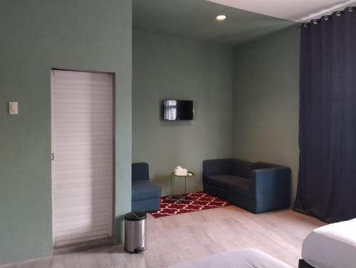 棉兰Vosstel Guest House的带沙发和椅子的客厅