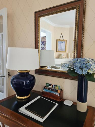 a table with a lamp and a mirror on a table at Maison Trianon 1928 in Quiévrechain