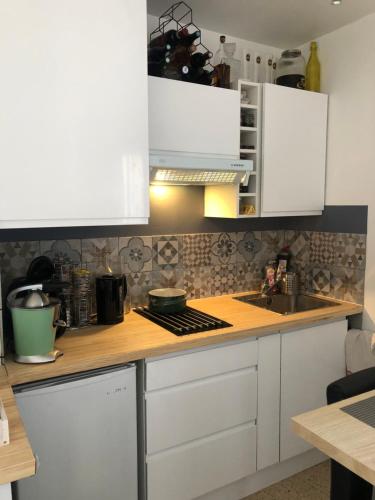 eine Küche mit weißen Schränken und einer Spüle in der Unterkunft T2 relax in Six-Fours-les-Plages