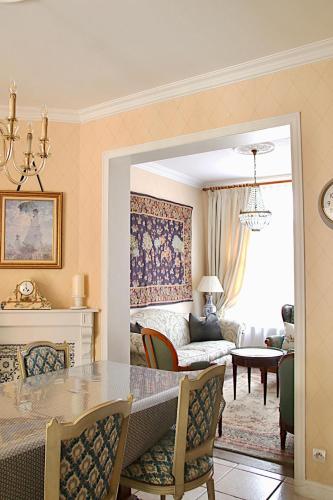 a dining room with a dining table and a living room at Maison Trianon 1928 in Quiévrechain