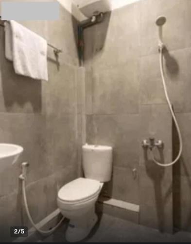 a bathroom with a white toilet and a shower at Vosstel Guest House in Medan