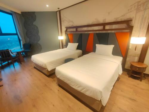 a hotel room with two beds and a table at Apec Mandala Chambay Mũi Né in Ấp Thiẹn Ái