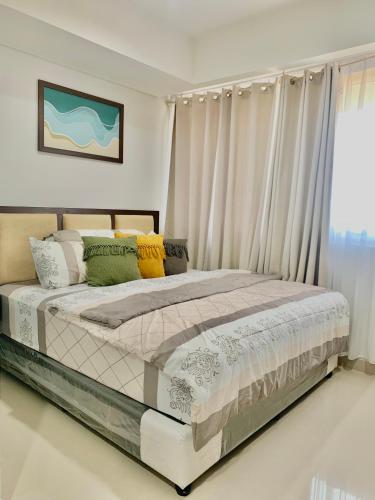 a bedroom with a bed with curtains and a window at Nuvasa Bay Studio Apartment 6A10 in Nongsa