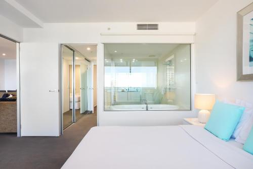 a white bedroom with a large bed and a bath tub at Circle on Cavill 2, 3, 4 & 5 Bedroom SkyHomes & SUB PENTHOUSES by Gold Coast Holidays in Gold Coast