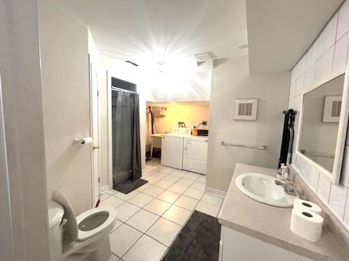 a white bathroom with a toilet and a sink at Leslie in Wasaga Beach