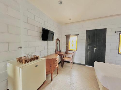 a kitchen with a refrigerator and a table and a desk at Ammara Legian By Vilarisi in Legian