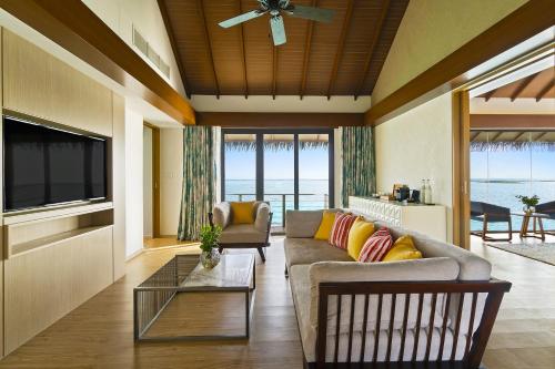 a living room with a couch and a tv at Pullman Maldives Maamutaa - All-Inclusive Resort - 50 percent off Transfers in Maamutaa