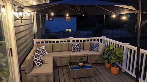 a porch with a couch and an umbrella at Spacious and Elegant Space with Premium Kitchen that is Ideal for Gathering with Friends and Family in Middleton