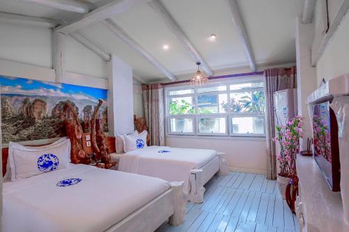 a bedroom with two beds and a window at Zhoujia Hostel in Zhangjiajie