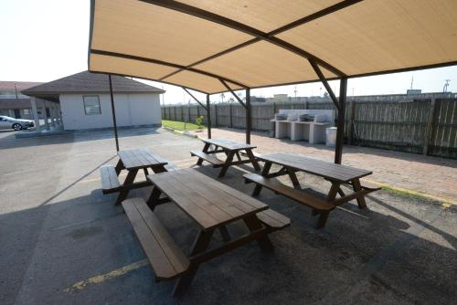 a group of picnic tables under a large umbrella at Port Isla Inn in Port Isabel
