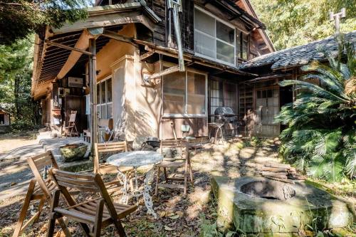 a house with a table and chairs in front of it at ゲストハウス+カフェわ　１日１組限定！ 築１００年の農家の古民家で宿泊体験、薪でお風呂沸かせます。焚き火もできます。 in Kannami