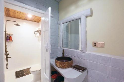 a bathroom with a sink and a toilet and a window at Zhoujia Hostel in Zhangjiajie
