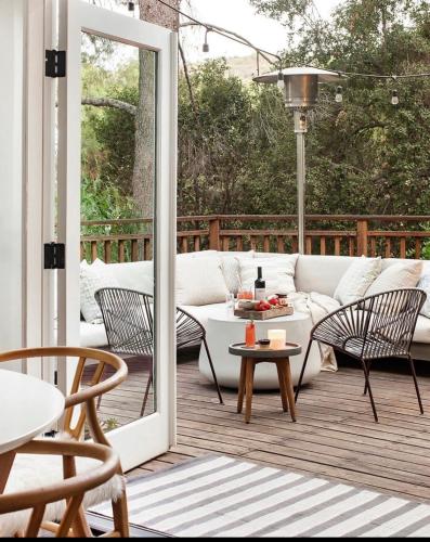 a patio with a white couch and chairs on a deck at Zen Treehouse Retreat-Great Views & Peaceful Decks in Los Angeles