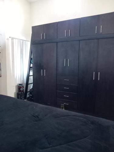 a bedroom with black cabinets and a black bed at ROSARITO-LUX Ranch in Rosarito