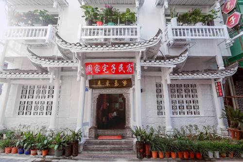 a white building with plants in front of it at Zhoujia Hostel in Zhangjiajie