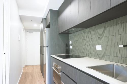 una cucina con un lavello e un bancone di Modern apt in heart of the city a Canberra