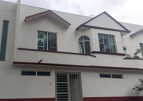 une maison blanche avec des fenêtres au-dessus dans l'établissement Departamento los pinos 1, à Zurumútaro