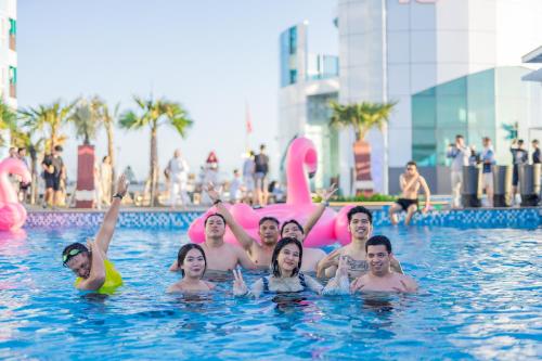 a group of people in a swimming pool at The All - Suite Pentacity Hotel Balikpapan in Balikpapan