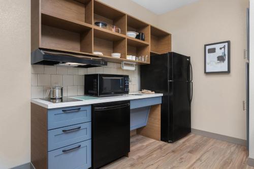 a kitchen with a black refrigerator and a microwave at Candlewood Suites La Crosse by IHG in La Crosse