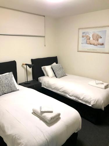 a room with two beds with towels on them at Mountain View Chalet at Heidis in Smiggin Holes