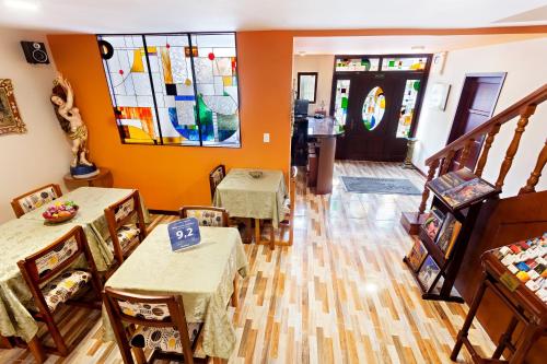 a living room with tables and chairs and a stained glass window at Hotel Francés La Maison in Pasto
