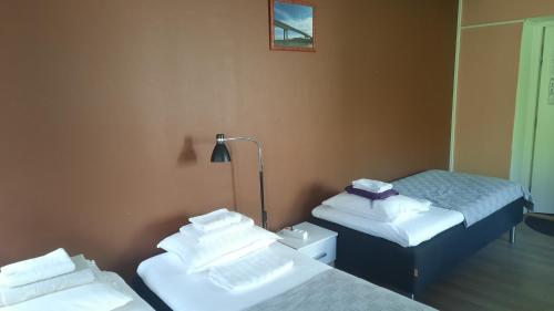 a room with two twin beds and a lamp at Imatran Portti in Imatra