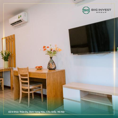 a dining room with a table and a tv on a wall at BIG Apartment Ha Noi in Hanoi