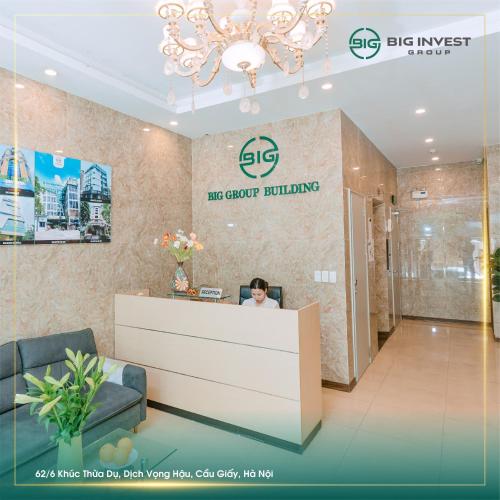 a woman sitting at a reception desk in a lobby at BIG Apartment Ha Noi in Hanoi