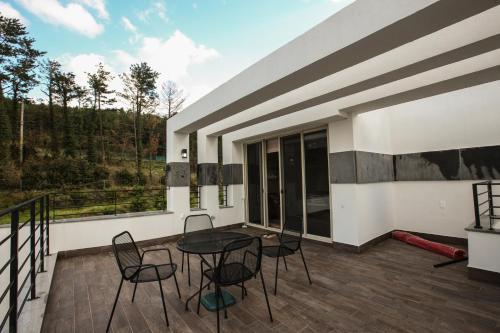 a patio with a table and chairs on a balcony at The Stay Christmas in Jeju
