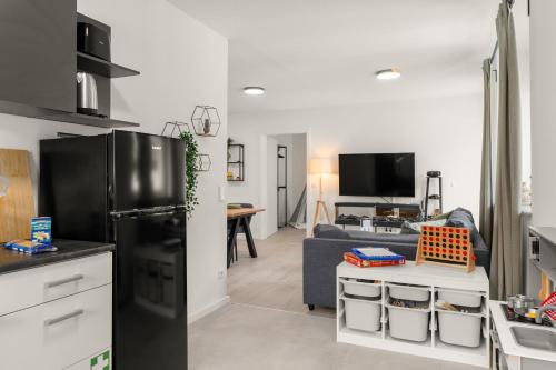 a kitchen and living room with a black refrigerator at EasyCastle 6P Terasse Switch TV in Bad Driburg
