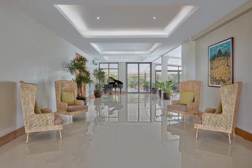 a hallway with chairs and a piano in a building at Holiday Inn & Suites Batangas LimaPark by IHG in Batangas City