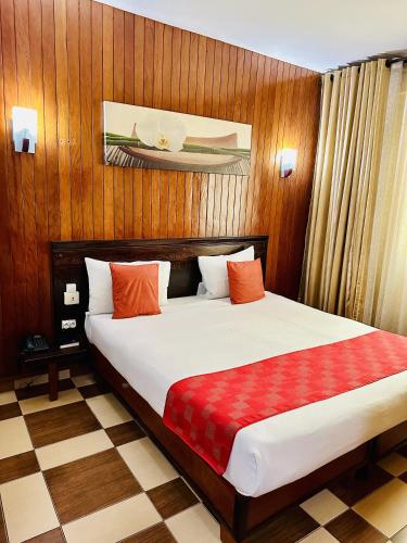 a bedroom with a large bed with wood paneling at Yaahot in Yaoundé