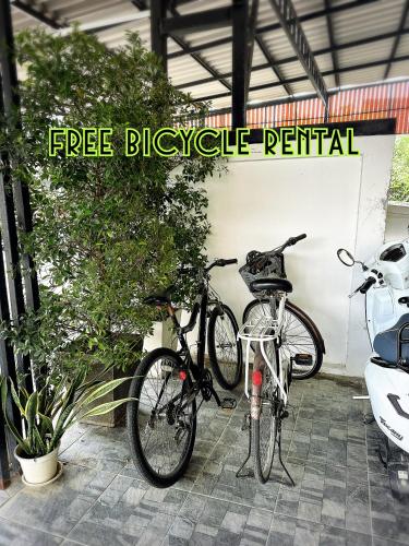 two bikes parked in a garage next to a car at Service Apartment ห้อง102 ใจกลางเมืองใกล้แหล่งท่องเที่ยว in Lampang