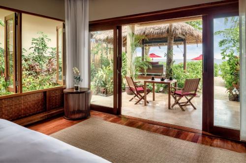 a bedroom with a bed and a table and chairs at Anantara Rasananda Koh Phangan Villas in Thong Nai Pan Noi