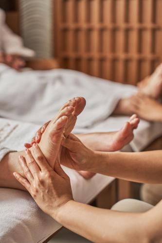 two people laying on beds with their feet up at Luxcity Hotel & Apartment in Phnom Penh