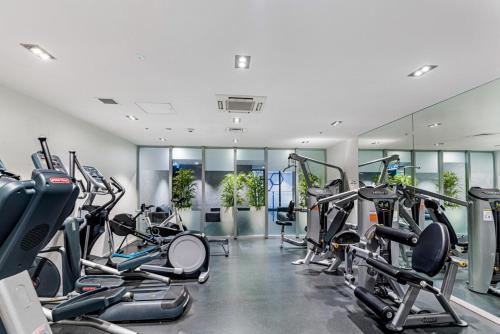a gym with several treadmills and cardio machines at Stylish Modern Unit w Balcony and Pool Zodiak Stays in Auckland