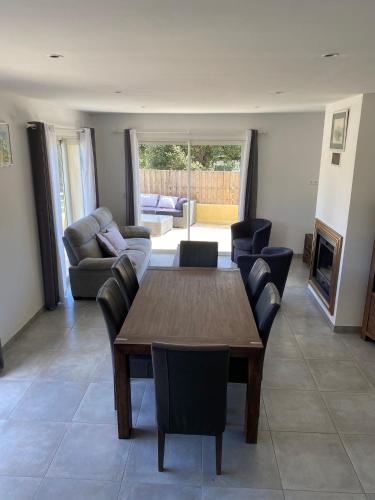 un salon avec une table et des chaises en bois dans l'établissement Les arbousiers de Murateddu, à Porto-Vecchio