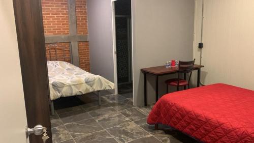 TlatlauquitepecにあるSuite Ariesのベッドと小さなテーブルのある部屋