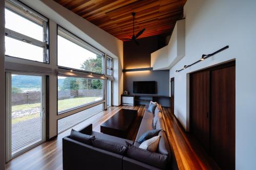 a living room with a couch and a tv at Private villa FujiNagi in Oishi