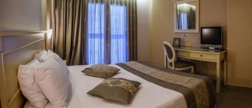 a hotel room with a bed and a desk with a computer at Ionion Beach Apartment Hotel & Spa in Arkoudi