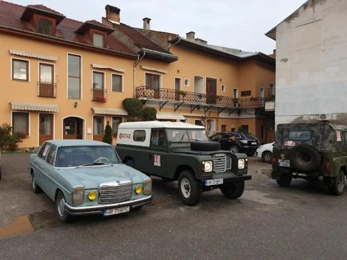 a truck and a jeep parked next to a building at Pension Ferdinand Panzio in Sfântu-Gheorghe