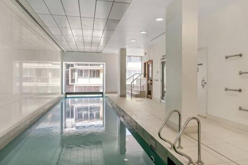 a large swimming pool in a large building with a swimming poolvisor at 2BRs Apartment on Balfours - Free WI-FI in Adelaide