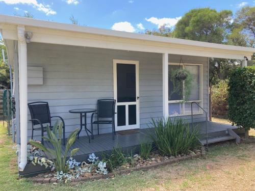 a porch of a house with a table and chairs at Waterfall Cottage in Rosebud