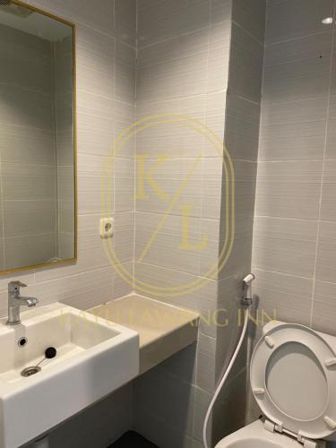 a bathroom with a sink and a toilet and a mirror at SkyView Apartment By Kayu Lawang in Sunggal