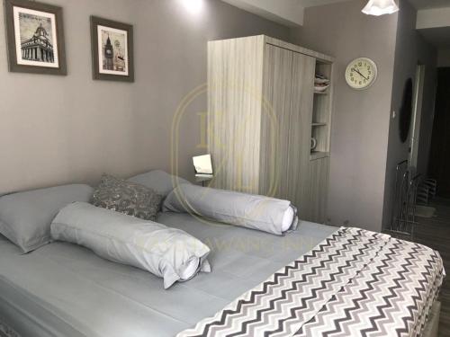 a bed with two pillows on it in a bedroom at SkyView Apartment By Kayu Lawang in Sunggal